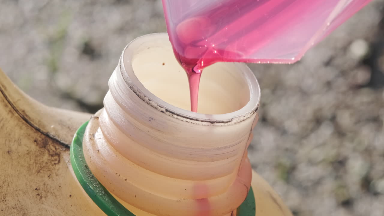 cámara lenta de aceite de motor que se vierte en el tanque de maquinaria