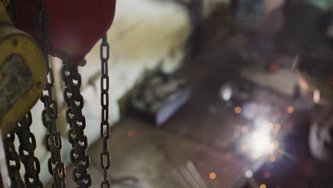 Caucasian-male-factory-worker-at-a-factory-making-standing-in-a-workbench,-welding,-