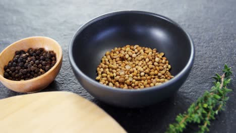 coriander seeds, black pepper, rosemary herbs and wooden board