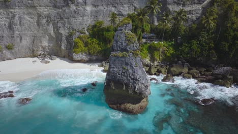 Pináculo-De-Roca-Con-Agua-Azul-Turquesa-En-La-Orilla-De-La-Playa-De-Diamantes,-Nusa-Penida,-Antena