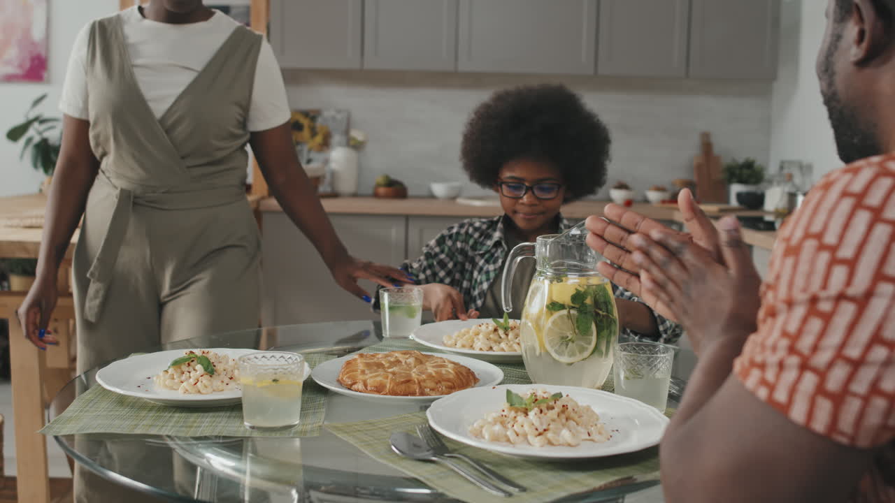 Famille afro-américaine de trois personnes priant avant de manger