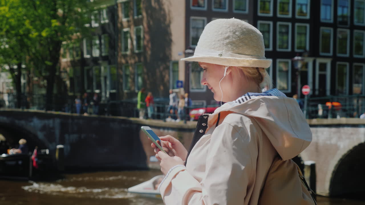암스테르담 중심가에서 스마트폰을 사용하는 여성