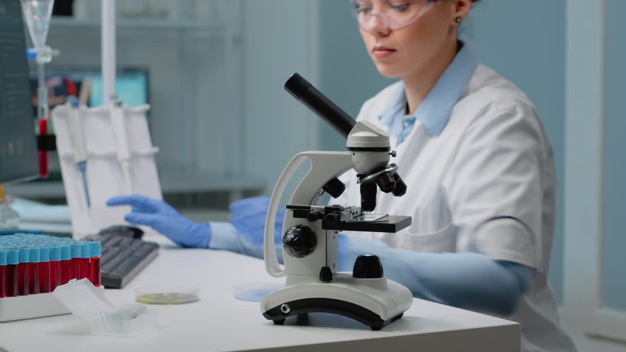 微鏡を使って研究室で働く科学者