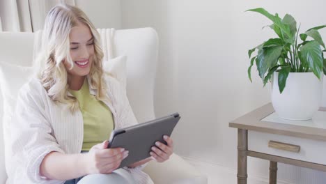 Happy-caucasian-plus-size-woman-using-tablet-and-having-video-call-in-slow-motion