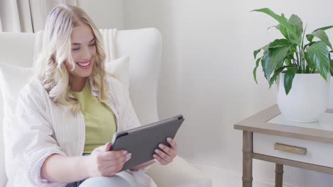 mujer caucásica feliz de talla grande usando una tableta y haciendo una videollamada en cámara lenta