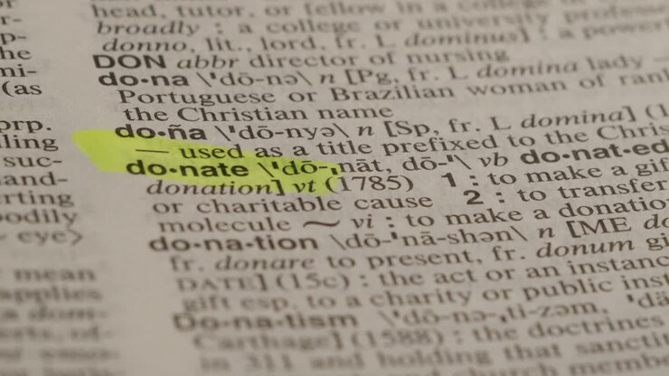 Donate Ordbogsmarkør Koncept, der fremhæver et ord i en ordbog for at vise dets definition