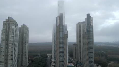 Aerial-shot-of-Puerto-Madero-modern-high-rise-buildings-and-luxury-hotels-under-the-foggy-sky,-Buenos-Aires,-Argentina