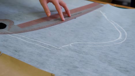 diseñador de moda marcando en la tela con tiza 4k