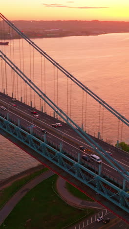 amazing sunset coloring everything in pink. whitestone bridge with fast moving cars over east river. vertical video