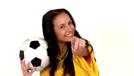 Cute-brunette-holding-football-and-pointing