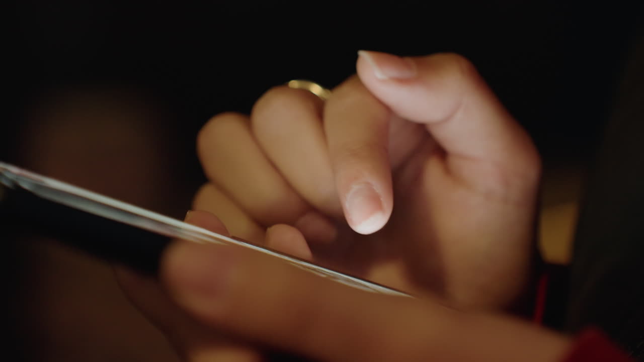Primo piano di giovani mani che toccano rapidamente lo schermo con un bagliore luminoso, scorrimenti veloci e pressioni con più dita, notifiche lampeggianti, energia notturna urbana e concentrazione, uso spontaneo del cellulare, ruoli inclusi