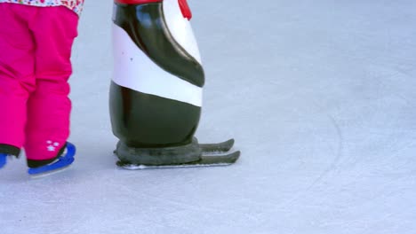 close up on kids learning ice skating on artificial ice rink