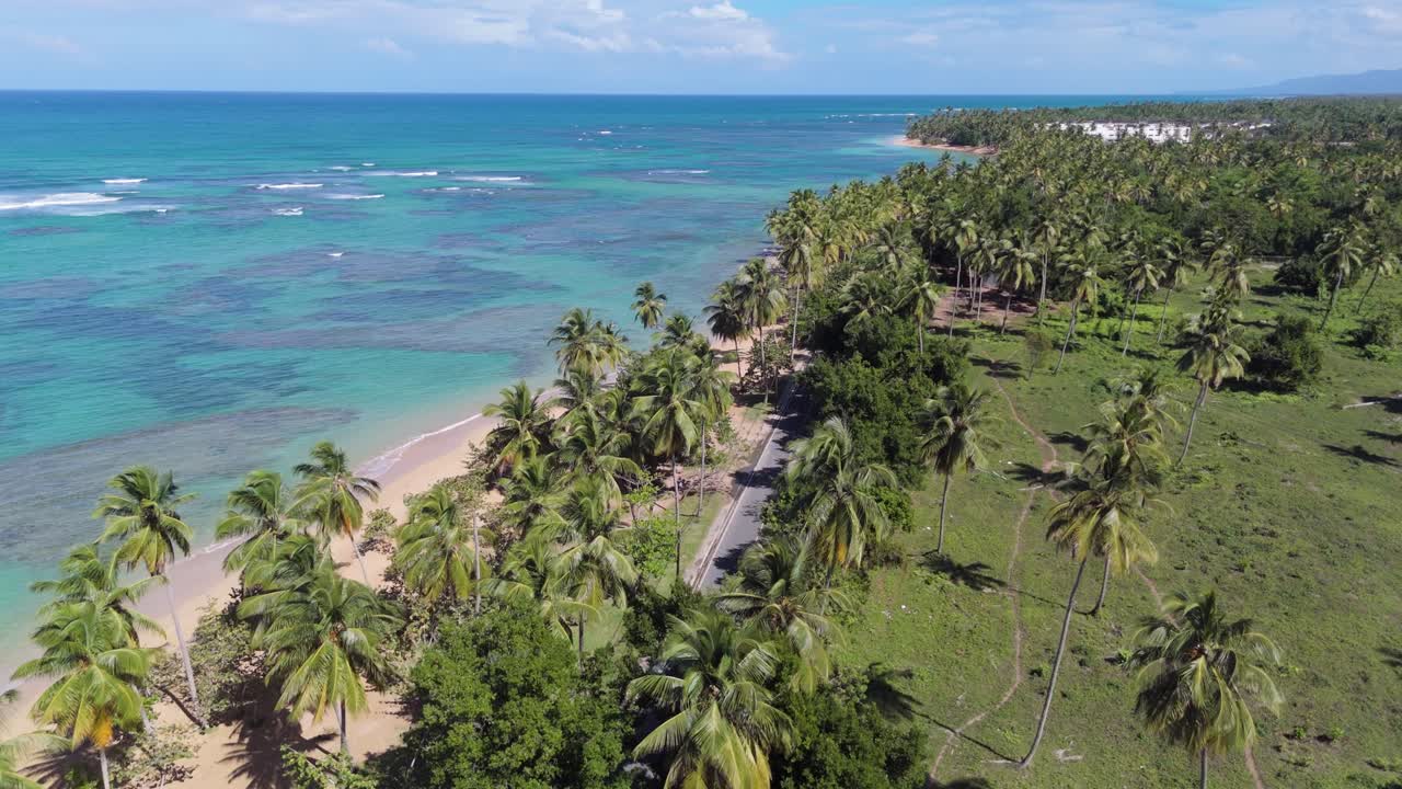 Coastal panoramic road along Playa El Portillo beach, tropical and exotic landscape, Las Terrenas in Dominican Republic. Aerial forward