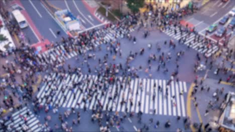 渋谷の商店街エリアで道路を横断する人々の上からの焦点技術のぼかしビュー