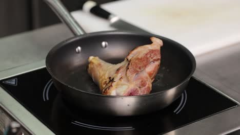 la pierna de cordero se está cocinando en una sartén.
