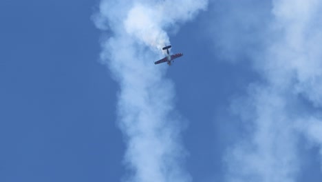 airplane executing loops and dives against blue sky