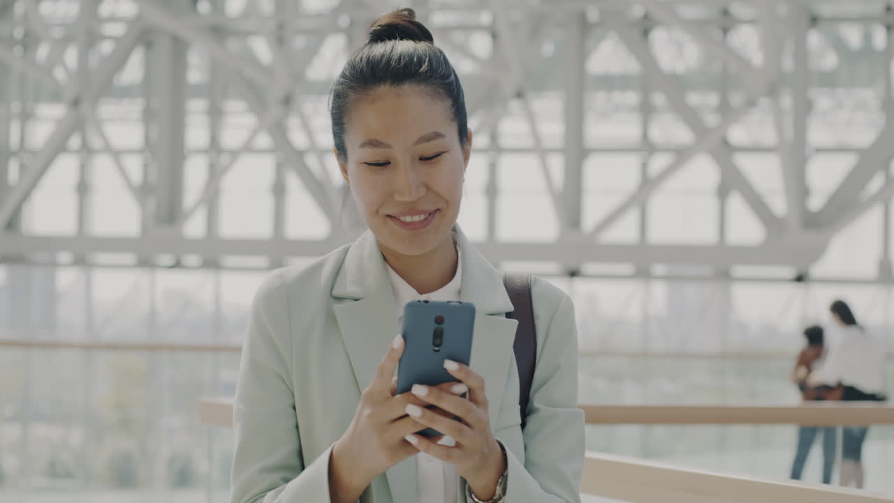 현대 건물에서 스마트폰을 사용하는 사업가