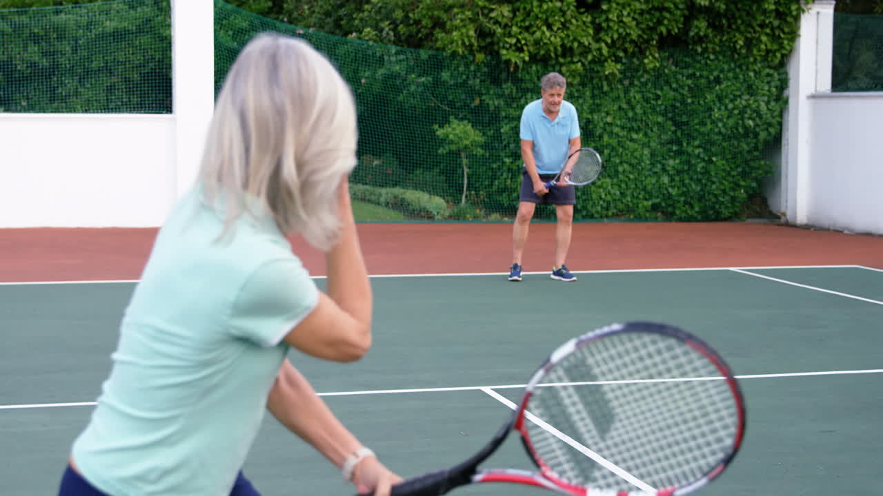 테니스 코트에서 테니스를 하는 고위 부부 4k