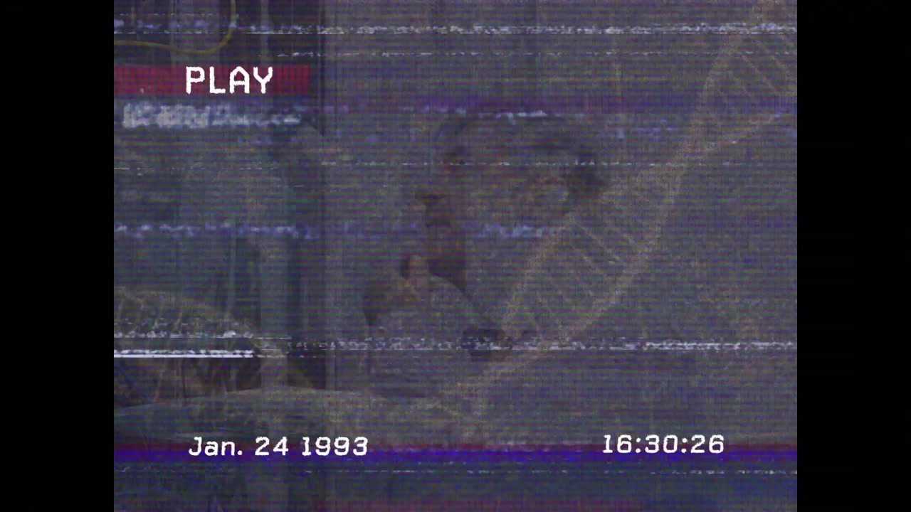 Man turning head speaking and gesturing through static interference revealing DNA mural in lab