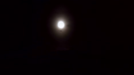 luna llena detrás de las nubes dramáticas en un cielo nocturno