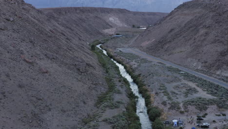 aerial view of tiny river running down deep valley