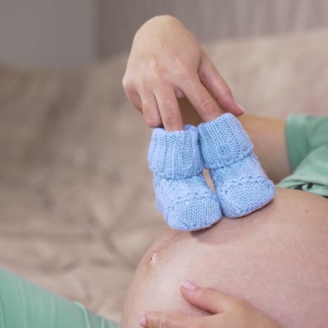 pregnant woman at home. young expecting woman holds baby in pregnant belly