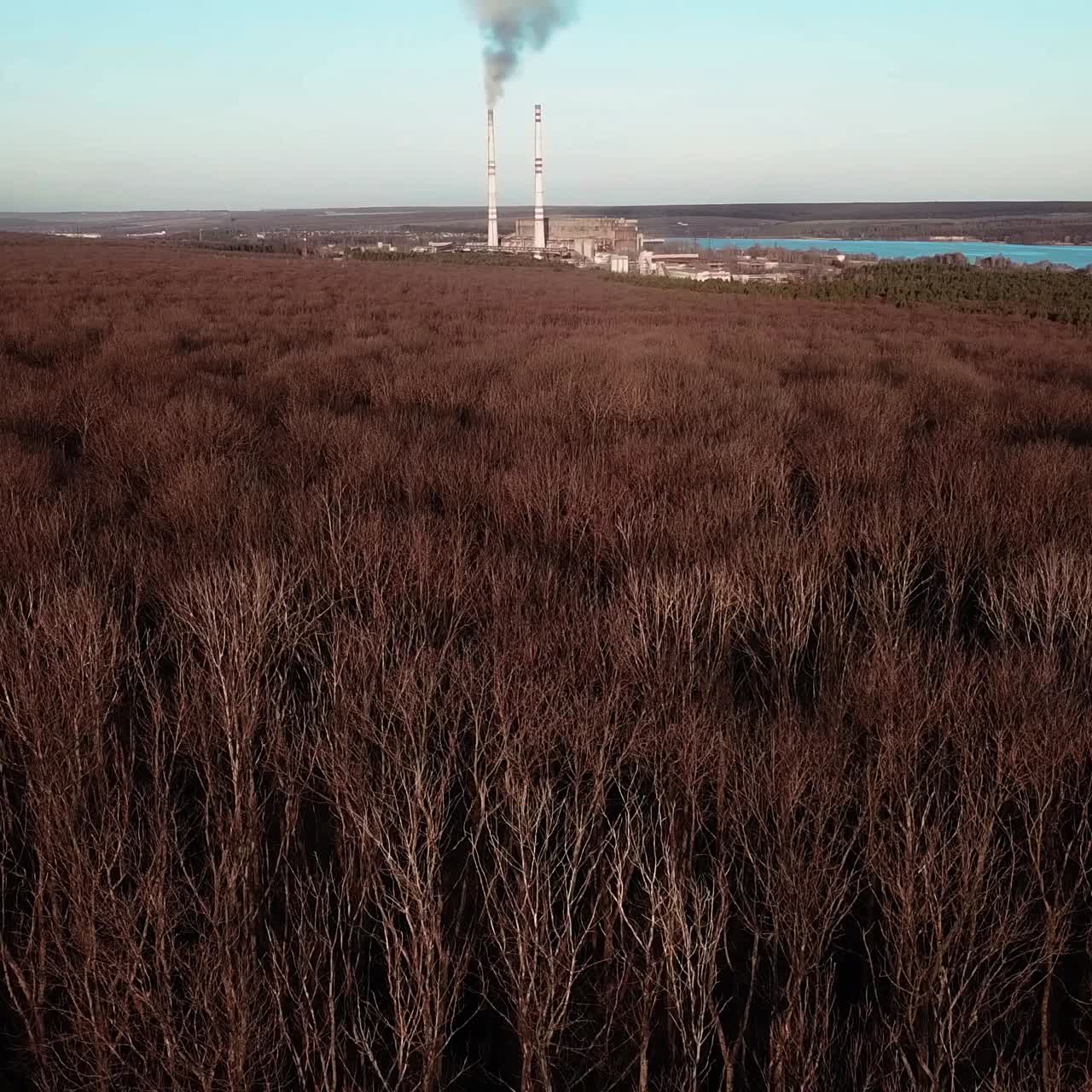 power station is working on the background of the river and the forest in the autumn. Aerial view