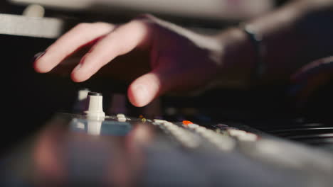 close-up of a person's hand playing a synthesizer