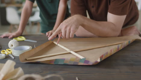 father and son making a kite together