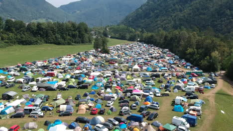Aerial-drone-shot-of-a-camping-ground-at-a-music-festival-in-a-green-and-lush-mountainous-area