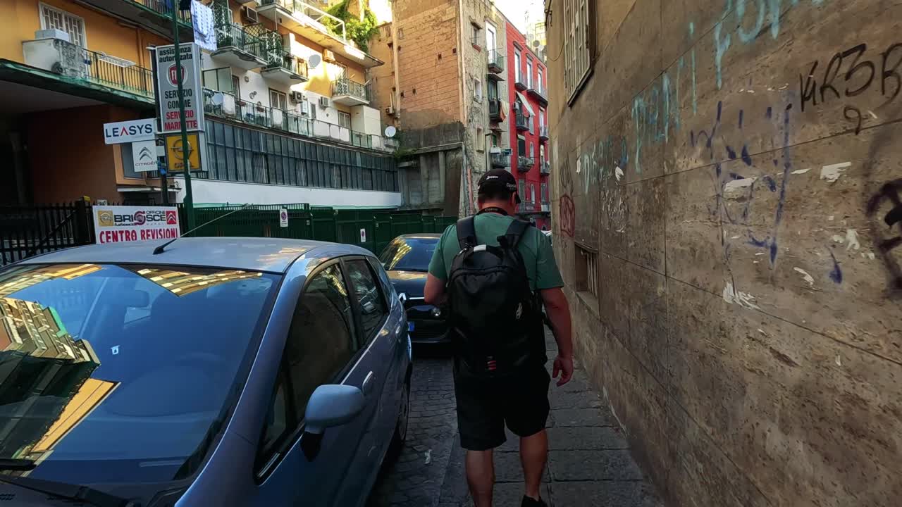 hombre navegando por un callejón estrecho con coches estacionados