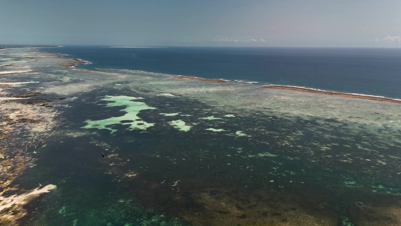 Filmatisk fugleperspektiv av et levende korallrev under krystallklart tropisk vann. Fantastisk luftperspektiv som avslører fargerike marine økosystemer, revstrukturer og turkis havgradient.