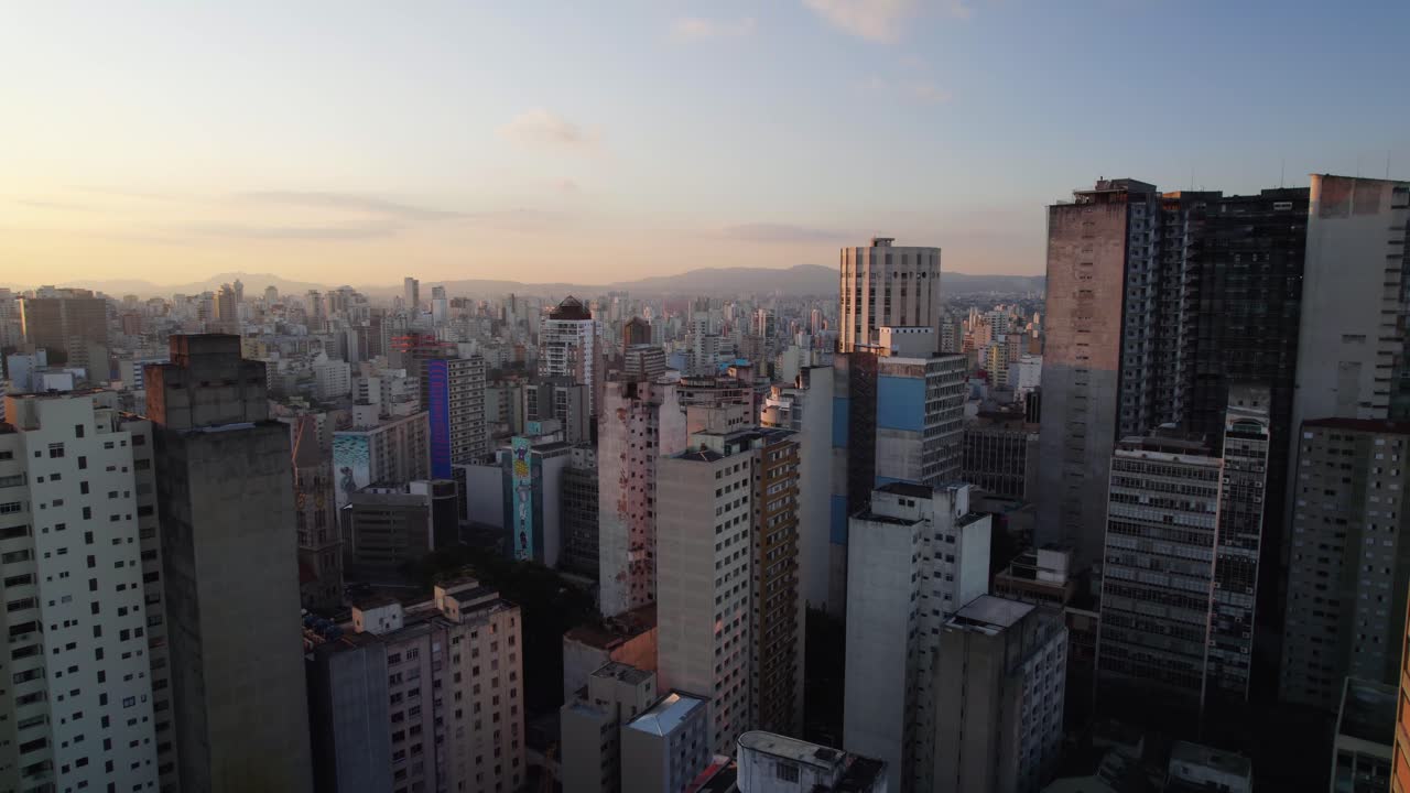 volando en medio de un antiguo rascacielos en la ciudad de sao paulo, puesta de sol en brasil - vista aérea