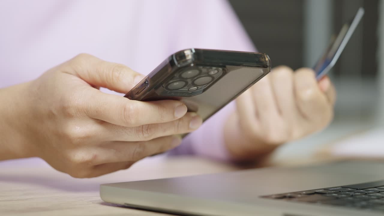 una mujer está usando una tarjeta de crédito para pagar compras en línea en una aplicación móvil por teléfono inteligente.