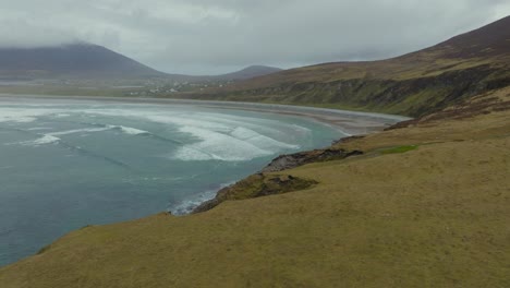 Revealing-shot-of-the-scenic-beach-at-Keel,-showing-the-waves-breaking-at-low-tide