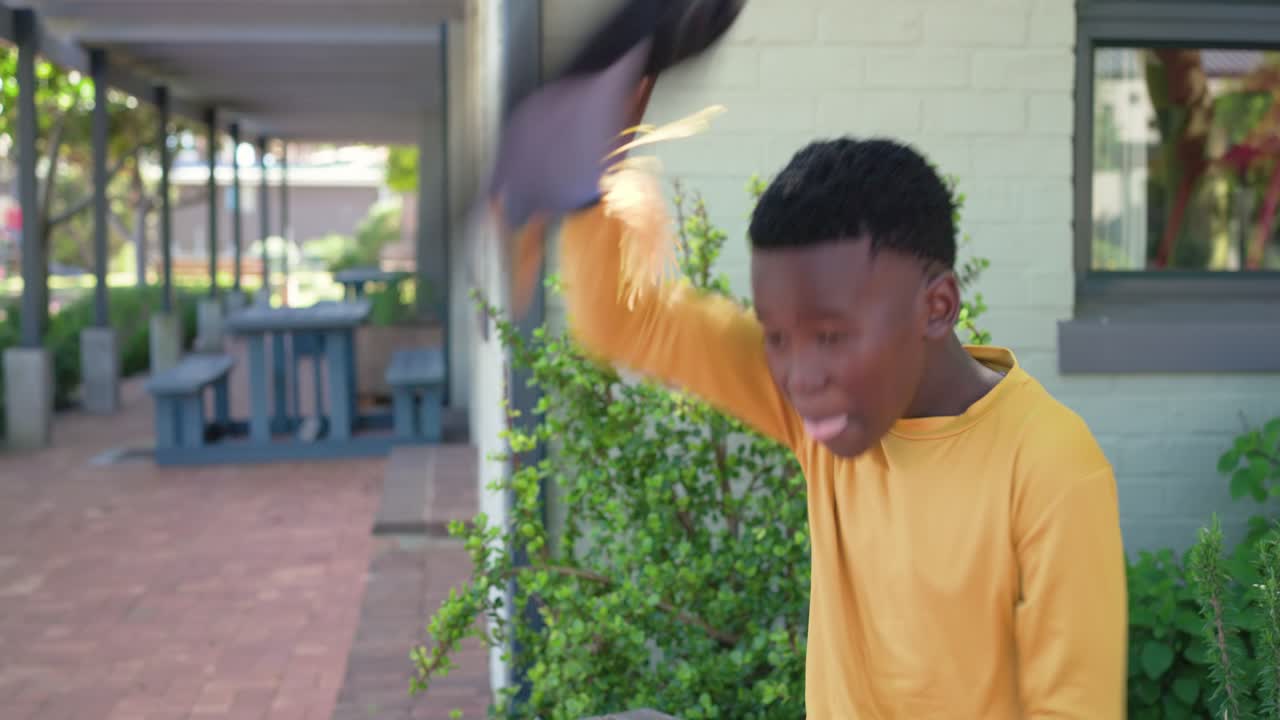 African youth male sitting bench under walkway after grad examining diploma tossing cap, copy space