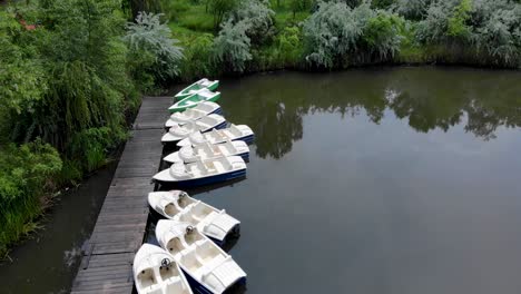 rental boats mooring on a wooden dock in calm lake