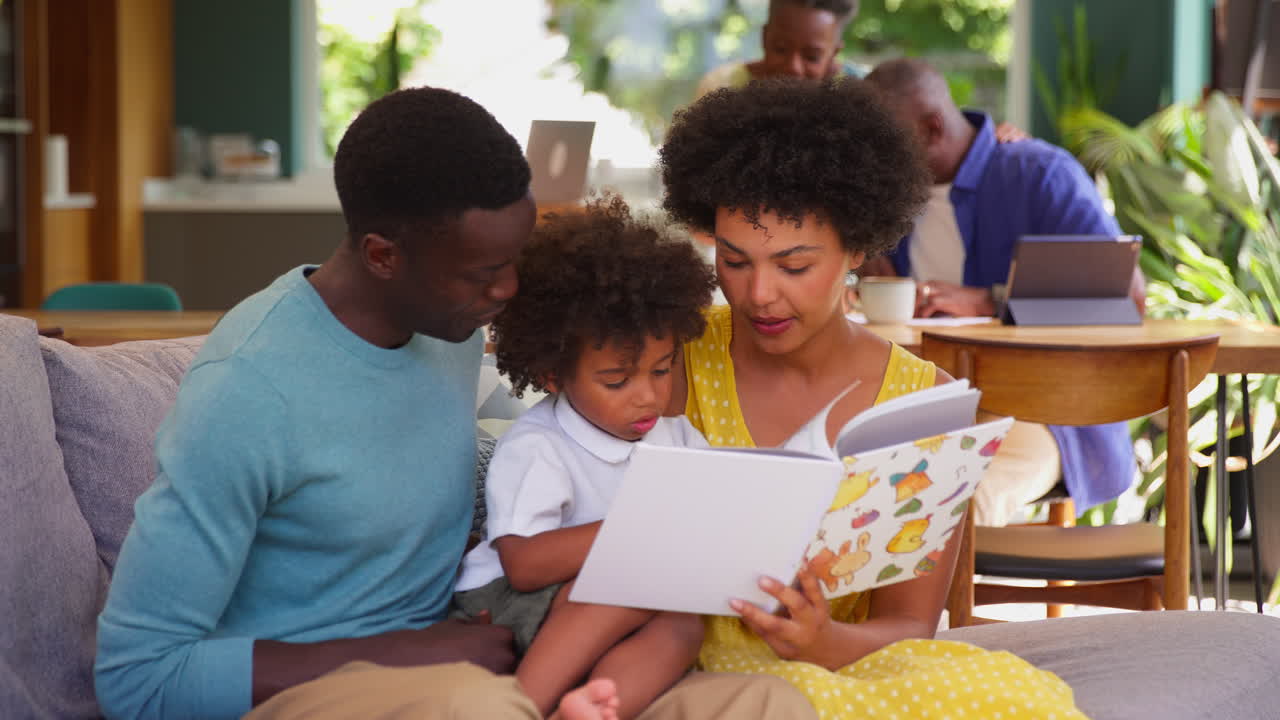Famiglia multigenerazionale con i genitori che leggono un libro al figlio e il nonno che aiuta la nipote.