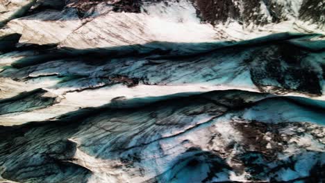 drone flies over blue and icy glacier in iceland