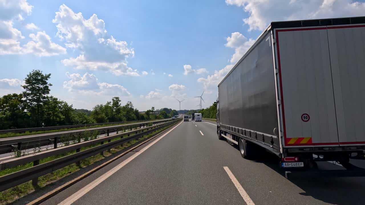 Large truck overtakes on sunny highway, lush greenery, blue sky, dynamic forward camera movement