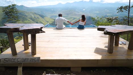 pareja saliendo en la cima de la montaña, tomados de la mano disfrutando de la compañía del otro