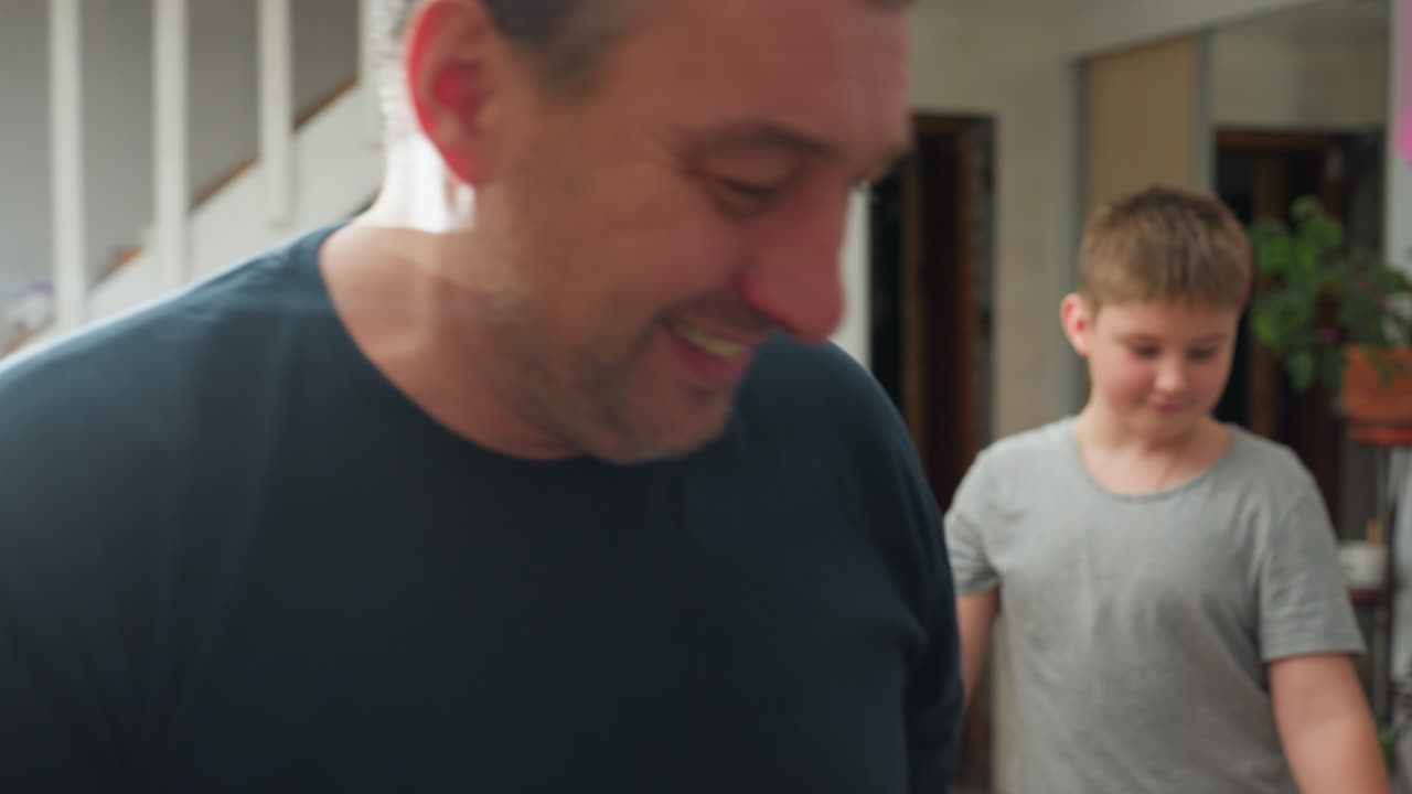 Husband, wife, and kid all in casual wear carrying a box and walking happily together in a festive atmosphere, ready to celebrate Christmas with smiles and joy
