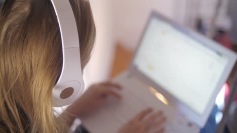 mujer con auriculares usando una computadora portátil