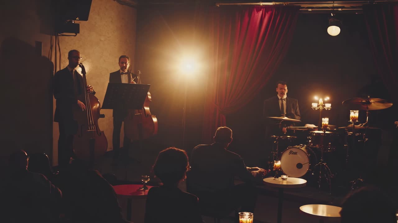 A saxophonist plays under warm spotlight against red curtains. The video captures a close-up angle