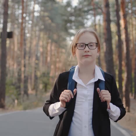 a child with a back pack walks alone through a park with tall trees 1