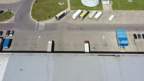 Aerial-Shot-of-Industrial-Warehouse-Loading-Dock-where-Many-Truck-with-Semi-Trailers-Load-Merchandise