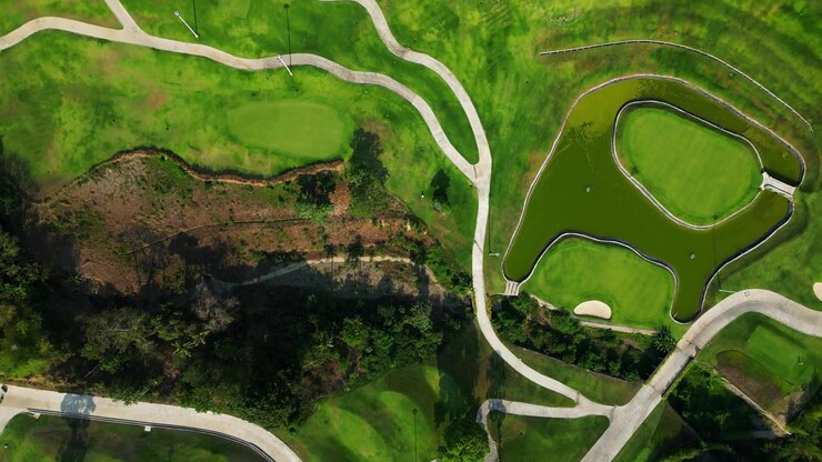 FPV flythrough above golf pathways in Tanauan City Batangas Philippines with lush greenery and cinematic tropical environment.