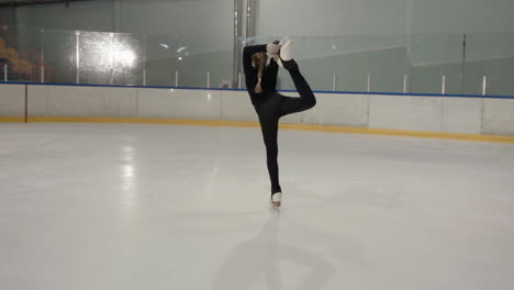 Imágenes-En-Cámara-Lenta-De-Una-Joven-Vestida-De-Negro-Patinando-En-Una-Pista-De-Hielo