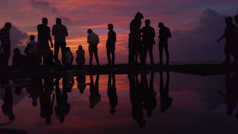 silhouette and reflection of people watching the sunset slow motion