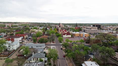 dolly aéreo a la catedral en pueblo colorado rodeado de barrio suburbano